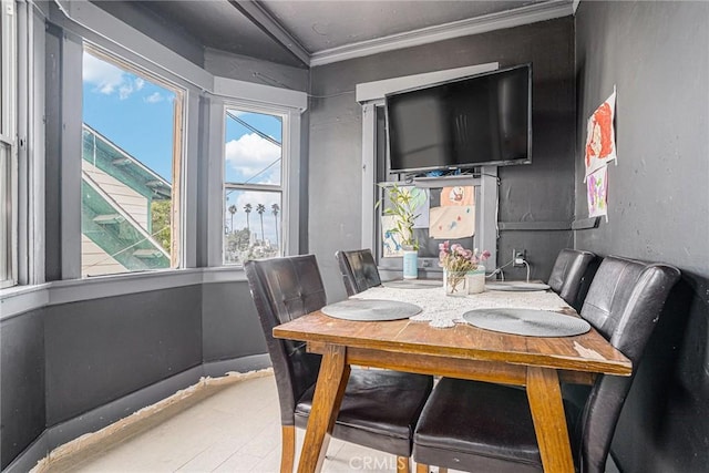 dining space with ornamental molding and wood finished floors