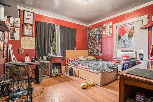 bedroom featuring ornamental molding and hardwood / wood-style flooring