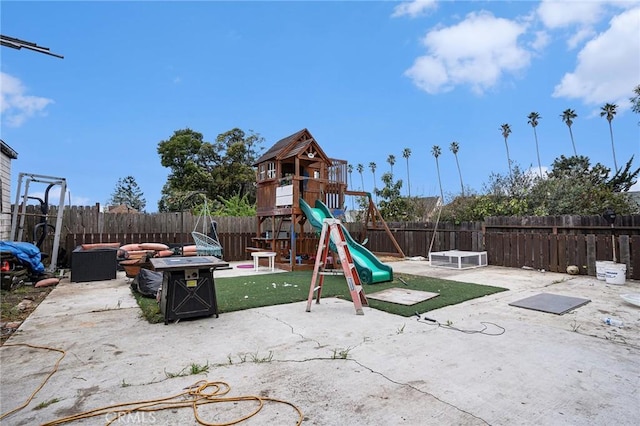 view of jungle gym with a fenced backyard, a patio area, and an outdoor fire pit