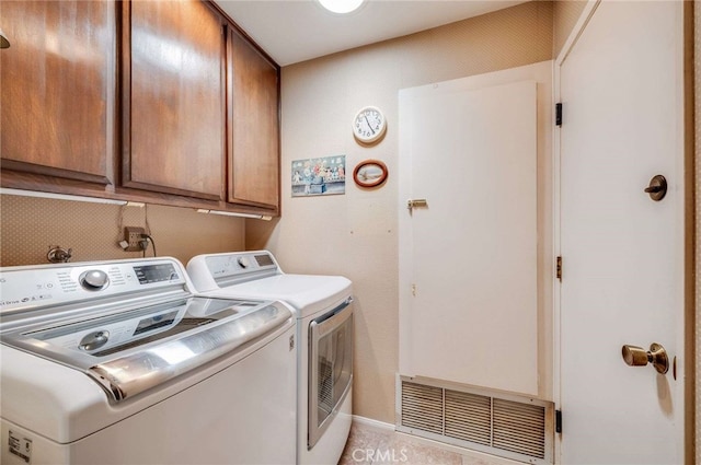 laundry area featuring visible vents, light tile patterned flooring, washer and dryer, baseboards, and cabinet space