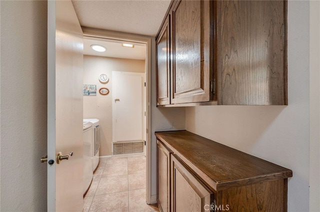 interior space with visible vents, baseboards, light tile patterned floors, and washing machine and clothes dryer