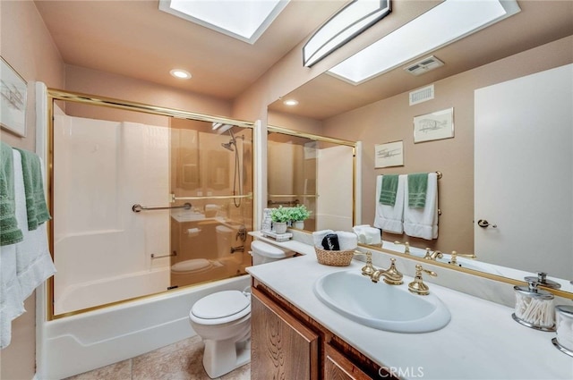bathroom featuring visible vents, vanity, toilet, combined bath / shower with glass door, and a skylight