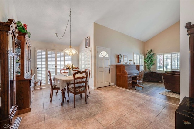 dining room featuring light tile patterned flooring, high vaulted ceiling, and a notable chandelier