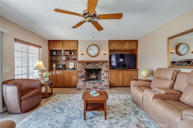 living room featuring built in shelves, a fireplace, a ceiling fan, and a textured ceiling