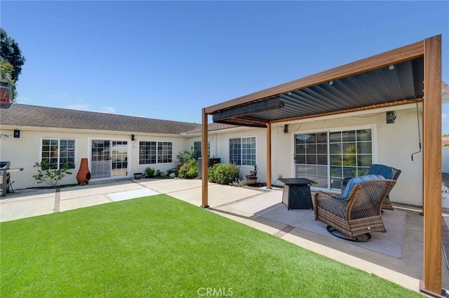 back of house with a lawn, a patio area, and stucco siding