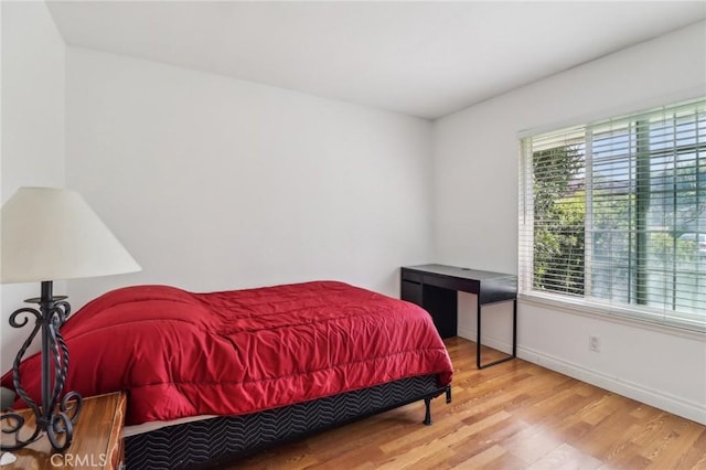 bedroom featuring baseboards and wood finished floors
