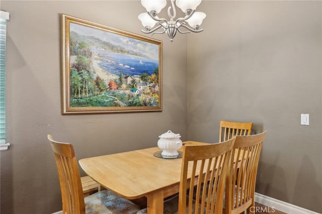 dining area featuring an inviting chandelier and baseboards