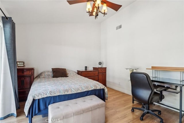 bedroom with light wood-style floors, a ceiling fan, baseboards, lofted ceiling, and visible vents