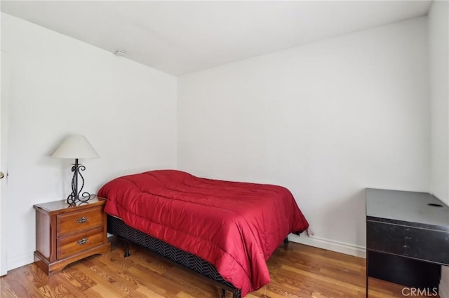 bedroom featuring baseboards and wood finished floors