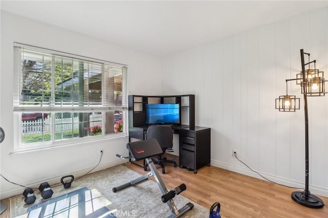 workout area with baseboards and wood finished floors