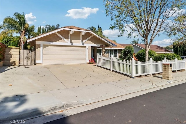 view of front of home with driveway, an attached garage, fence private yard, and stucco siding