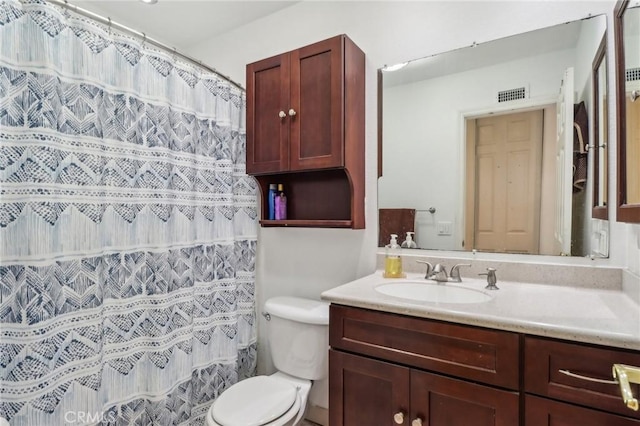 bathroom with visible vents, toilet, and vanity