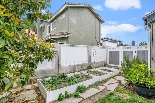view of yard featuring fence and a vegetable garden
