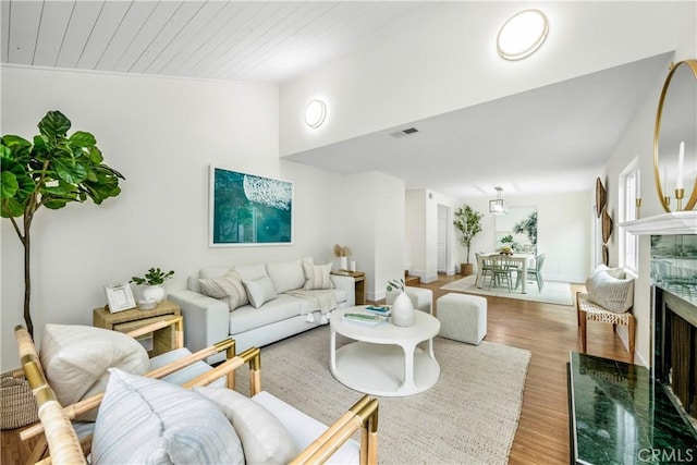 living area with wood ceiling, visible vents, wood finished floors, and vaulted ceiling