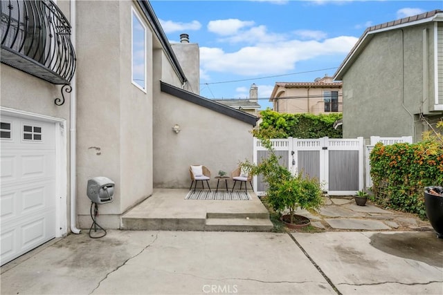 view of patio with a garage and fence