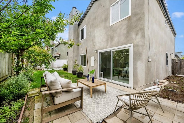 rear view of house with a fenced backyard, a patio area, and stucco siding