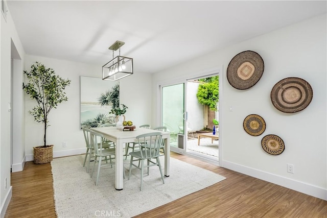 dining area with baseboards and light wood-style flooring