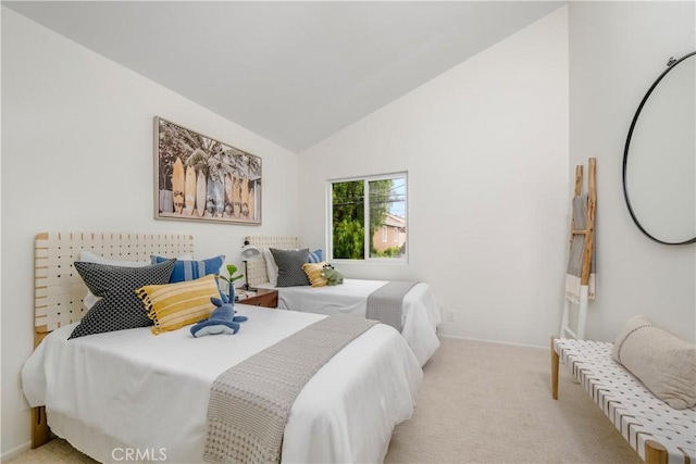 bedroom featuring baseboards, lofted ceiling, and light colored carpet