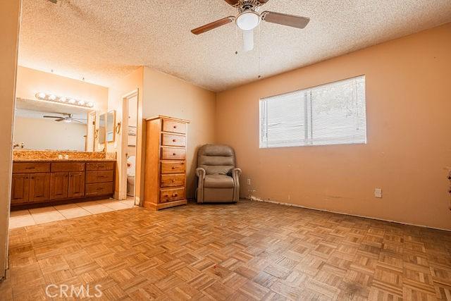 unfurnished room with ceiling fan and a textured ceiling