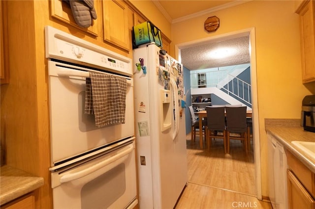 8060 Canby Ave Unit 2, Reseda, CA 91335 - kitchen with white appliances, ornamental molding, light wood finished floors, light countertops, and brown cabinetry