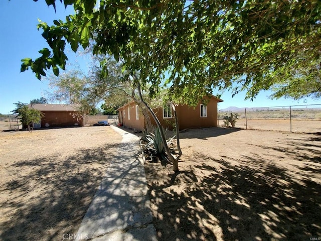 view of home's exterior with fence and stucco siding