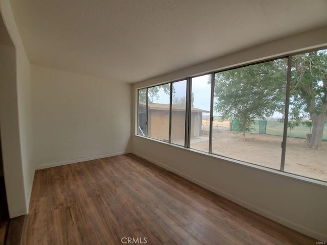 empty room featuring baseboards and wood finished floors