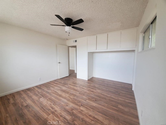unfurnished bedroom featuring a textured ceiling, visible vents, and wood finished floors