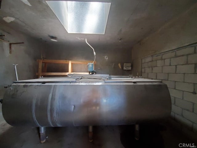 interior space featuring concrete block wall and heating fuel