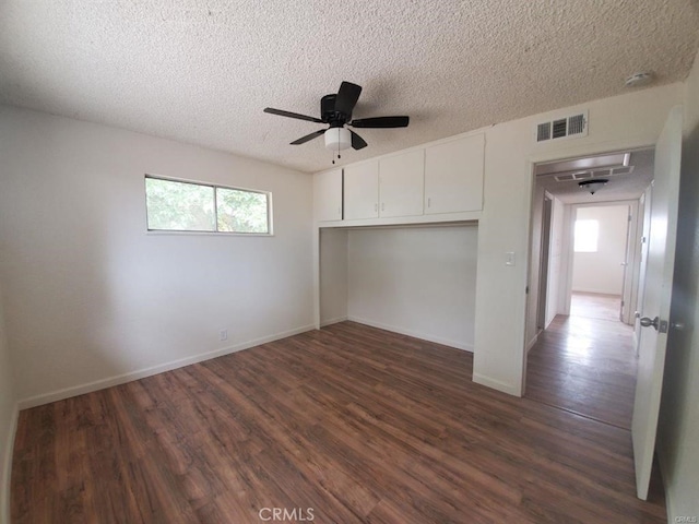 unfurnished bedroom with visible vents, a closet, baseboards, dark wood-style floors, and a textured ceiling