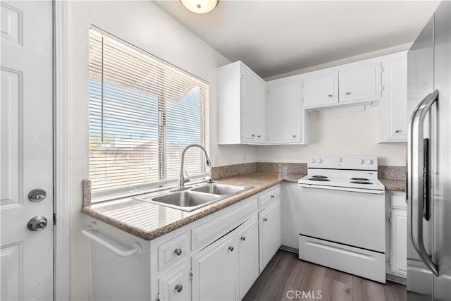 kitchen featuring electric range, a sink, stainless steel fridge, white cabinetry, and dark wood-type flooring