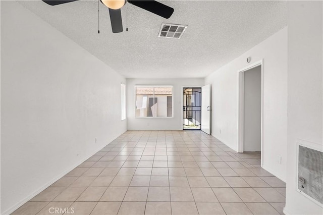 unfurnished room featuring ceiling fan, light tile patterned flooring, a textured ceiling, and visible vents