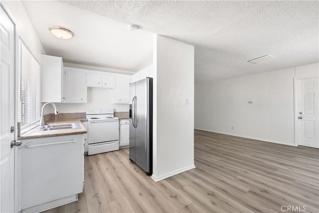 kitchen featuring a textured ceiling, white range with electric cooktop, a sink, stainless steel fridge, and light wood-style floors
