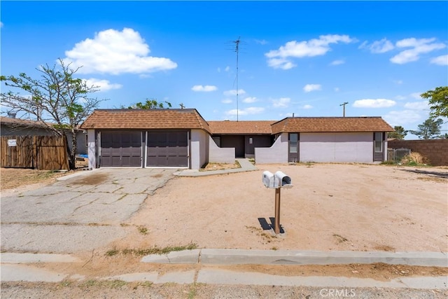ranch-style house featuring a garage, fence, stucco siding, and aphalt driveway