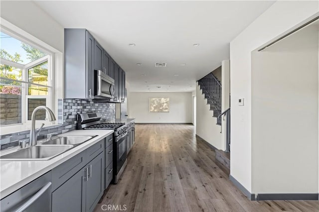 kitchen with plenty of natural light, a sink, light wood-style floors, and appliances with stainless steel finishes