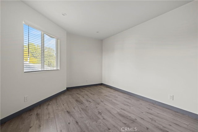 unfurnished room with baseboards and wood finished floors