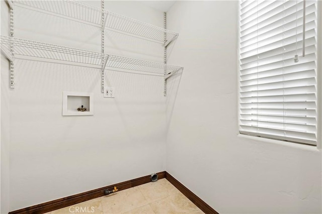 laundry area featuring light tile patterned floors, baseboards, laundry area, and hookup for a washing machine