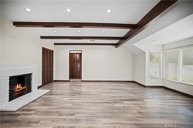 unfurnished living room with baseboards, recessed lighting, a brick fireplace, and wood finished floors