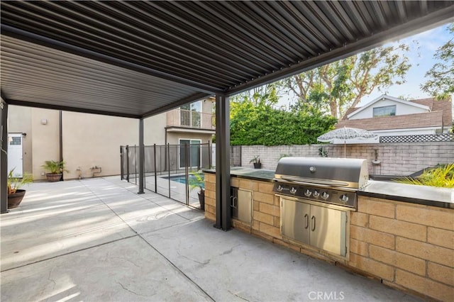 view of patio / terrace with an outdoor kitchen, a fenced backyard, and a grill