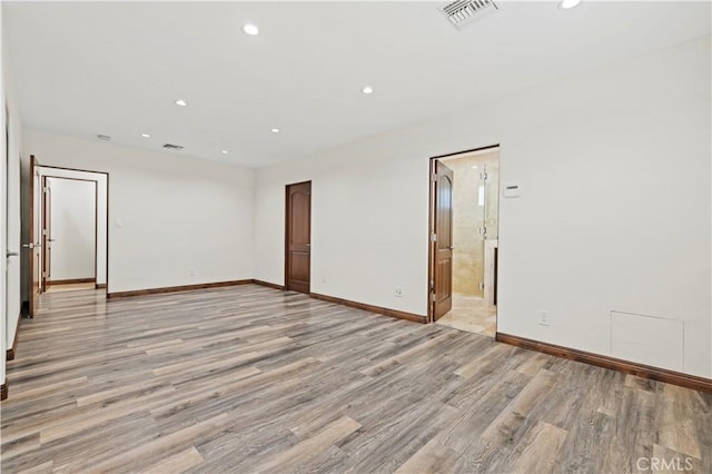empty room with light wood-style floors, baseboards, recessed lighting, and visible vents