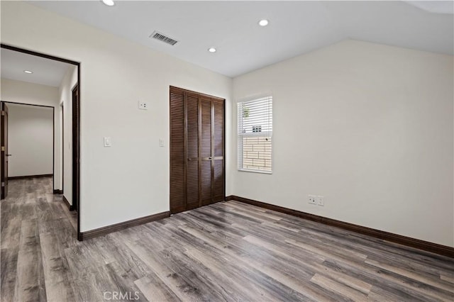 unfurnished bedroom featuring recessed lighting, visible vents, wood finished floors, and a closet