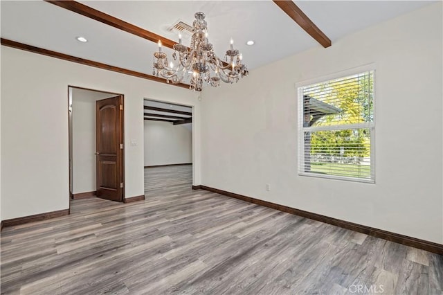 empty room featuring baseboards, beamed ceiling, wood finished floors, and a chandelier
