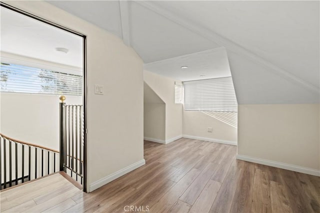 additional living space featuring plenty of natural light, lofted ceiling, and wood finished floors
