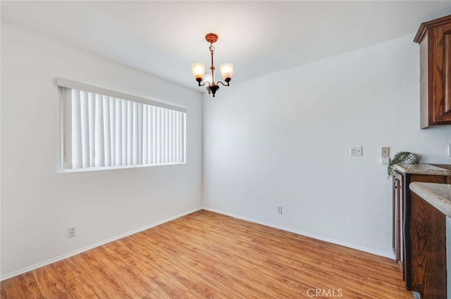 5400 Newcastle Ave Unit 56, Encino, CA 91316 - unfurnished dining area featuring baseboards, a chandelier, and light wood-style floors