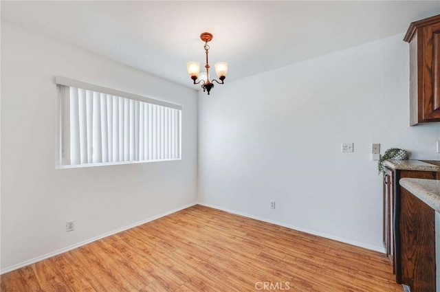 5400 Newcastle Ave Unit 56, Encino, CA 91316 - unfurnished dining area featuring a chandelier and light wood finished floors