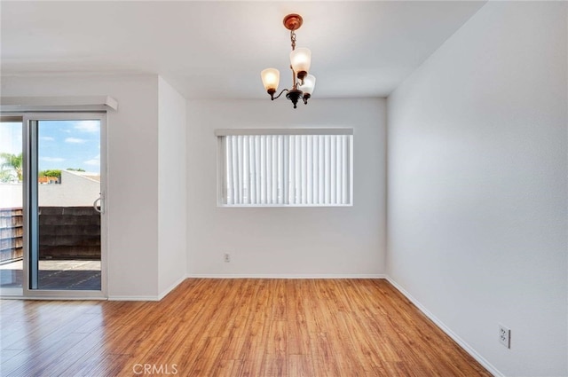 5400 Newcastle Ave Unit 56, Encino, CA 91316 - spare room featuring baseboards, a notable chandelier, and light wood-style flooring