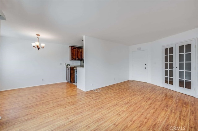 5400 Newcastle Ave Unit 56, Encino, CA 91316 - unfurnished living room featuring a notable chandelier, french doors, and light wood-style floors