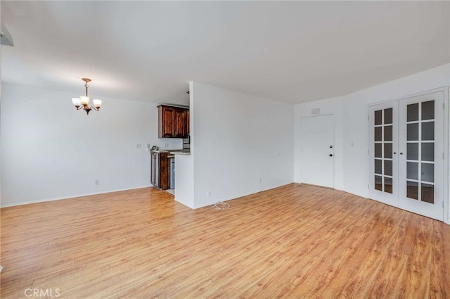 5400 Newcastle Ave Unit 56, Encino, CA 91316 - unfurnished living room with a chandelier, light wood-type flooring, and french doors