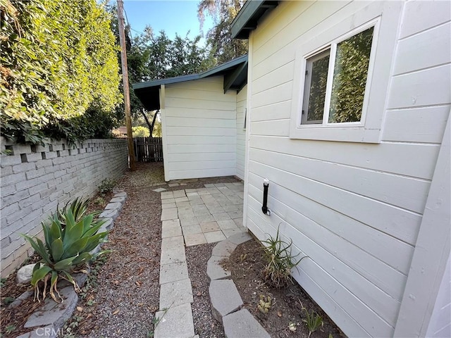 view of property exterior featuring fence and a patio area