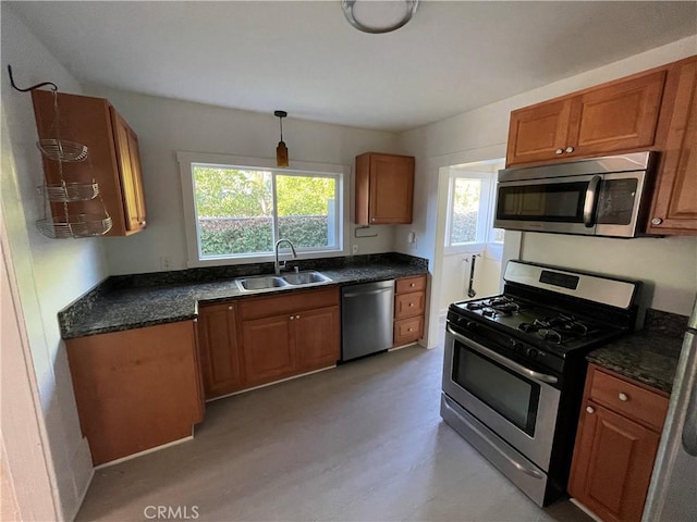 kitchen featuring a sink, appliances with stainless steel finishes, and brown cabinets