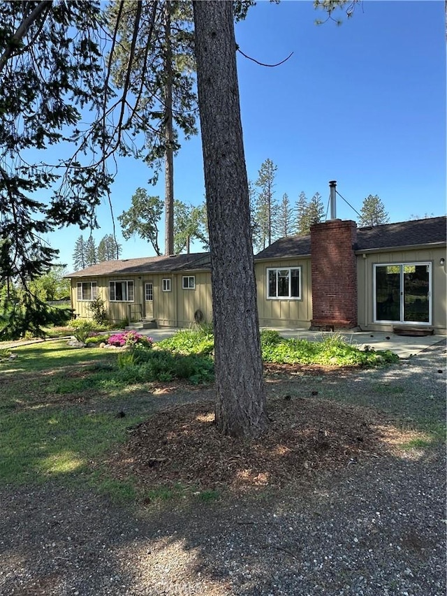 6322 Harvey, Paradise, CA 95969 - view of front of home with a patio, board and batten siding, and a chimney